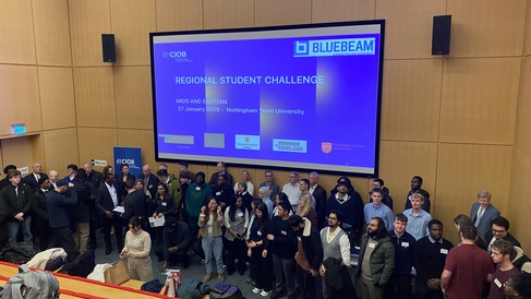 a group of 30 students stand in front of a board 